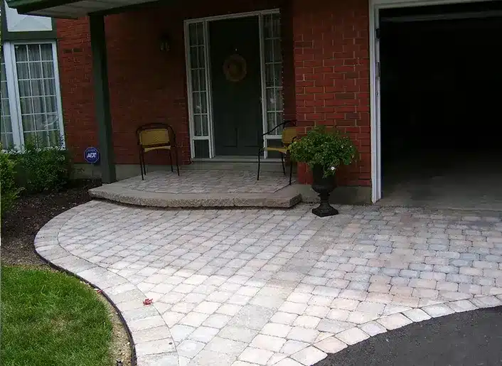 Curved interlock walkway beside a landscaped lawn